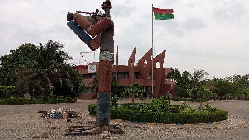 Sculpture d'un musicien devant le siège du FESPACO, drapeau du Burkina Faso au fond