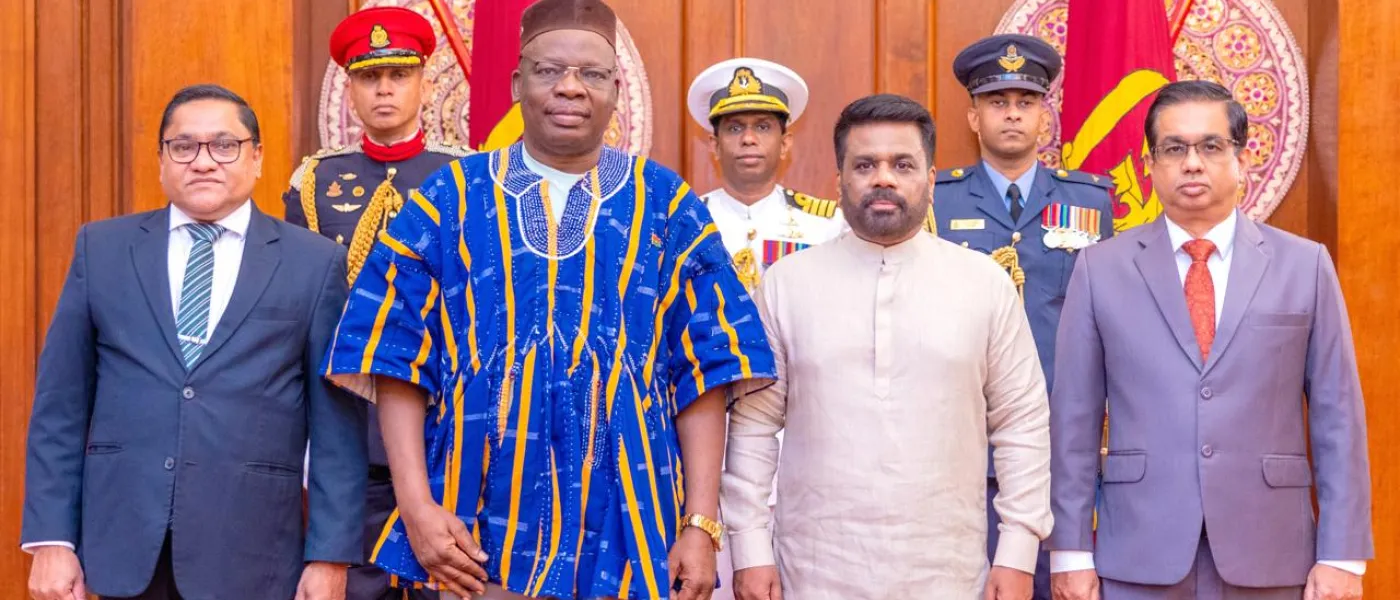 L'Ambassadeur du Burkina Faso en tenue traditionnelle aux côtés du Président du Sri Lanka Anura Kumara Dissanayake, devant les drapeaux sri-lankais