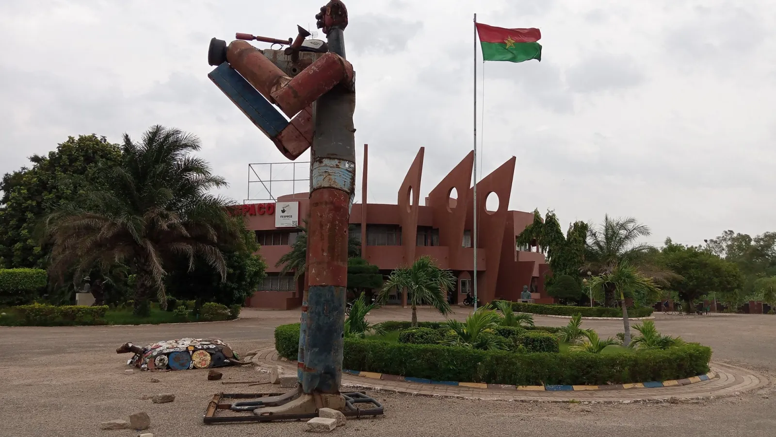 Sculpture d'un musicien devant le siège du FESPACO, drapeau du Burkina Faso au fond